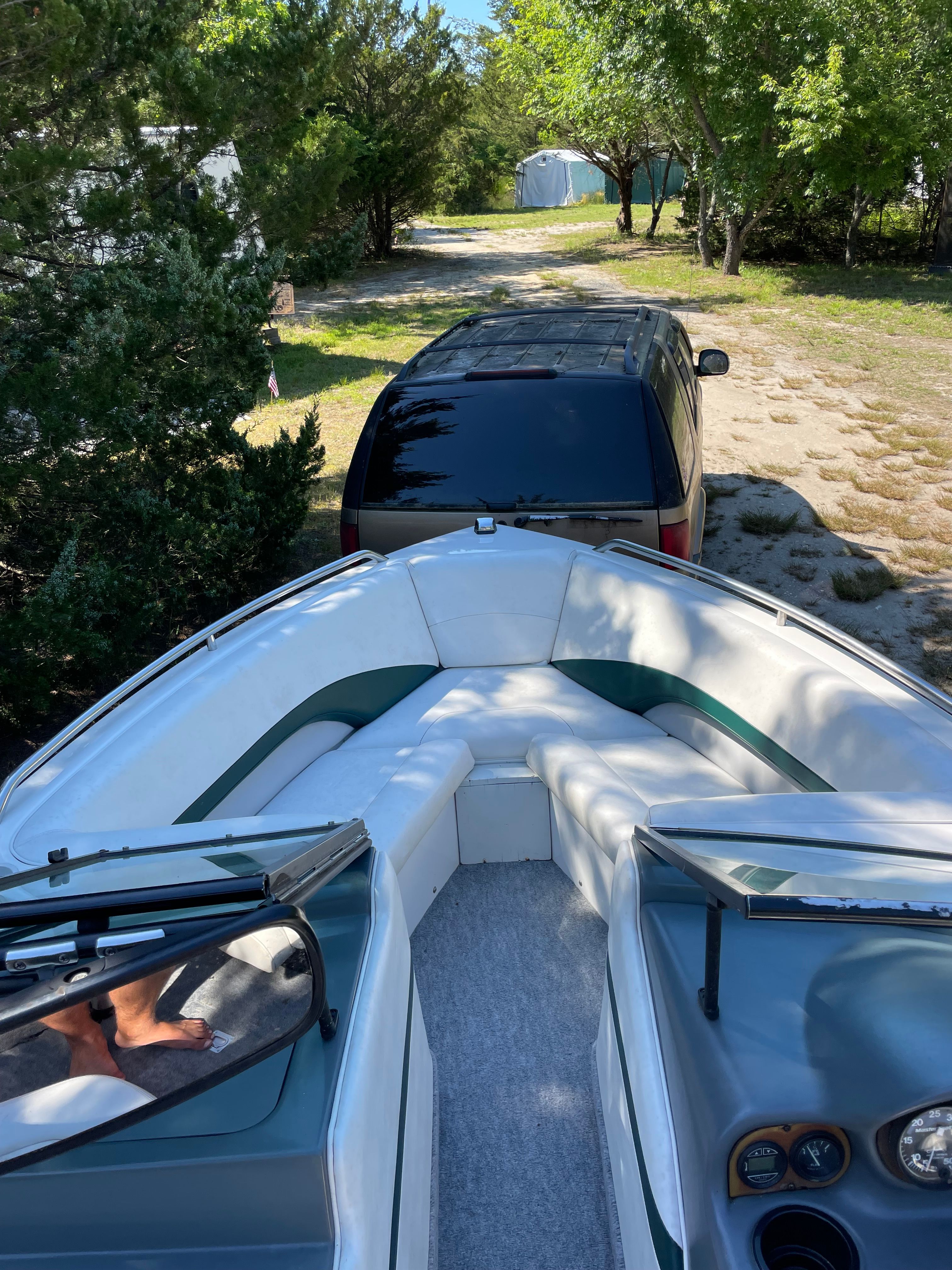 1997 MasterCraft Prostar 205 boat on trailer in a wooded area.