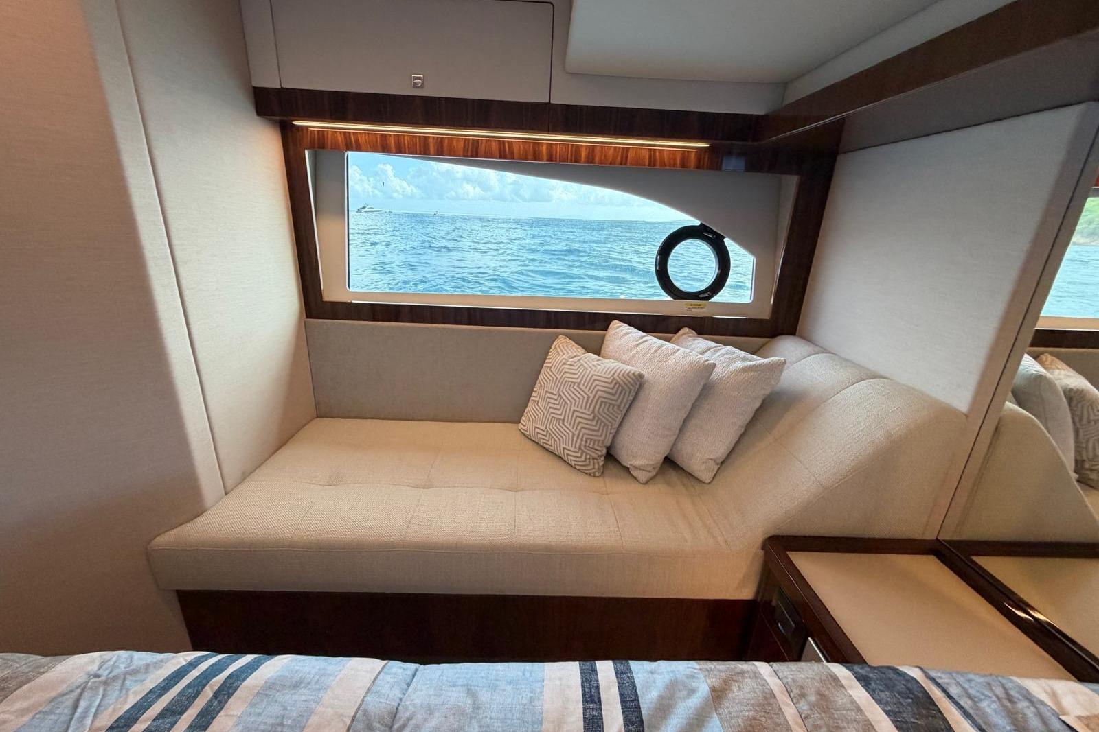 Luxurious interior of 2026 Riviera 505 SUV yacht with ocean view window.