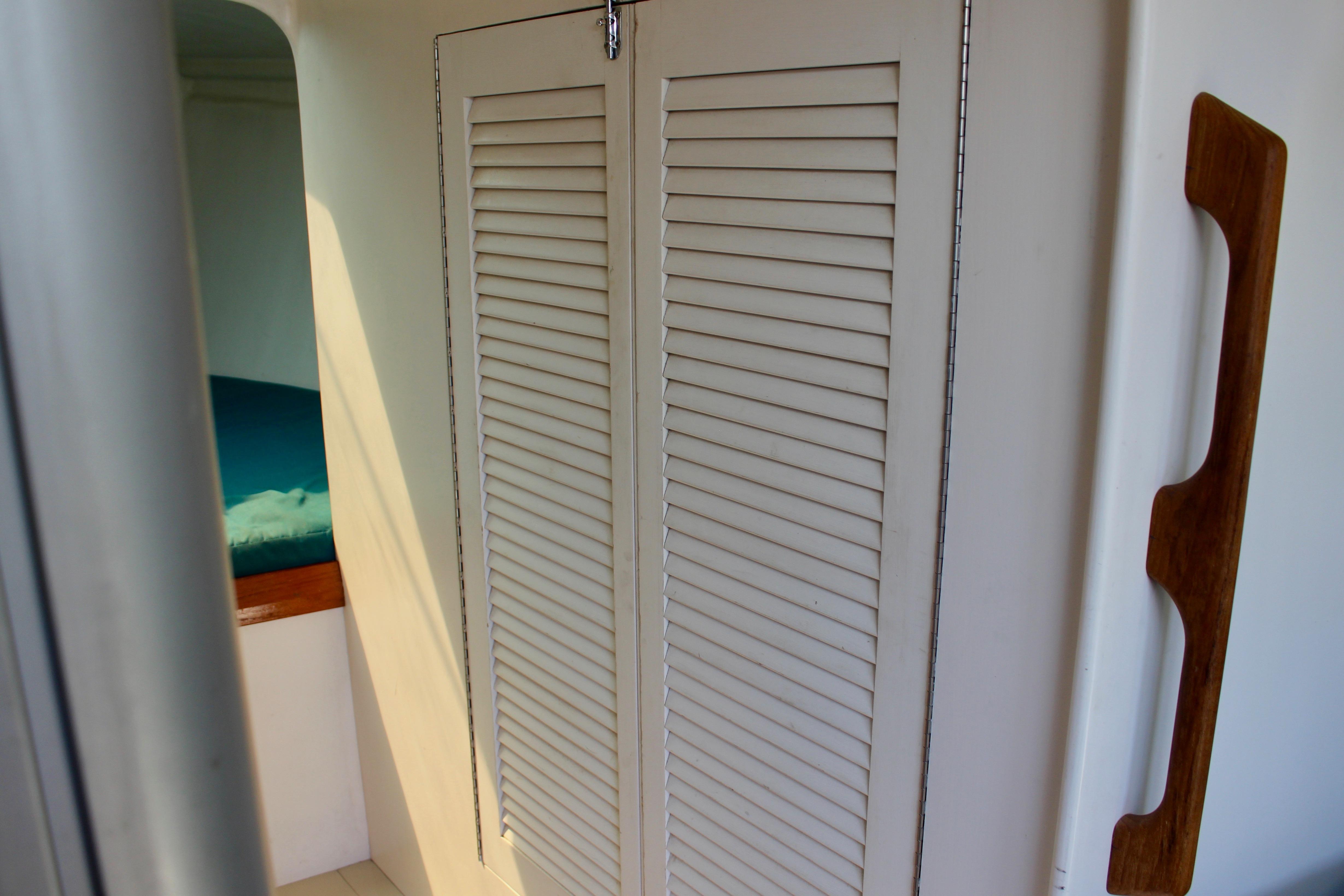Interior of 1993 Freya 39 sailboat with louvered closet doors and wooden handle.
