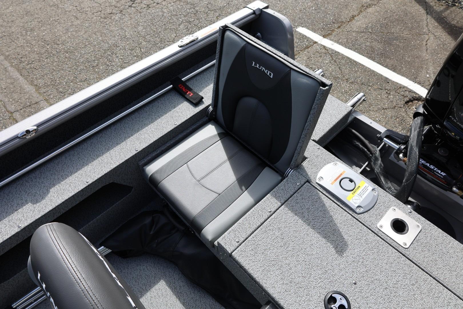 2026 Lund 1875 Impact XS Sport boat interior with gray seating and storage compartments.