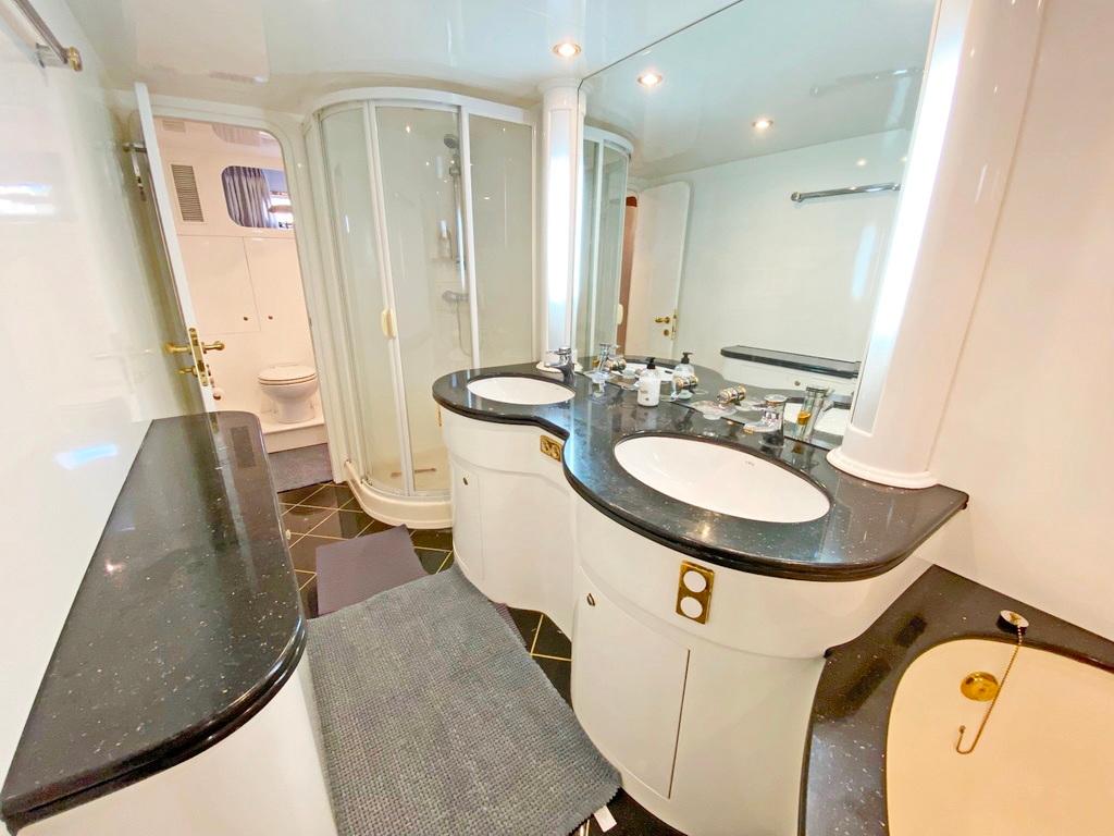 Luxurious yacht bathroom with dual sinks, shower, and elegant black countertops, Elegance 82 S, 2001.