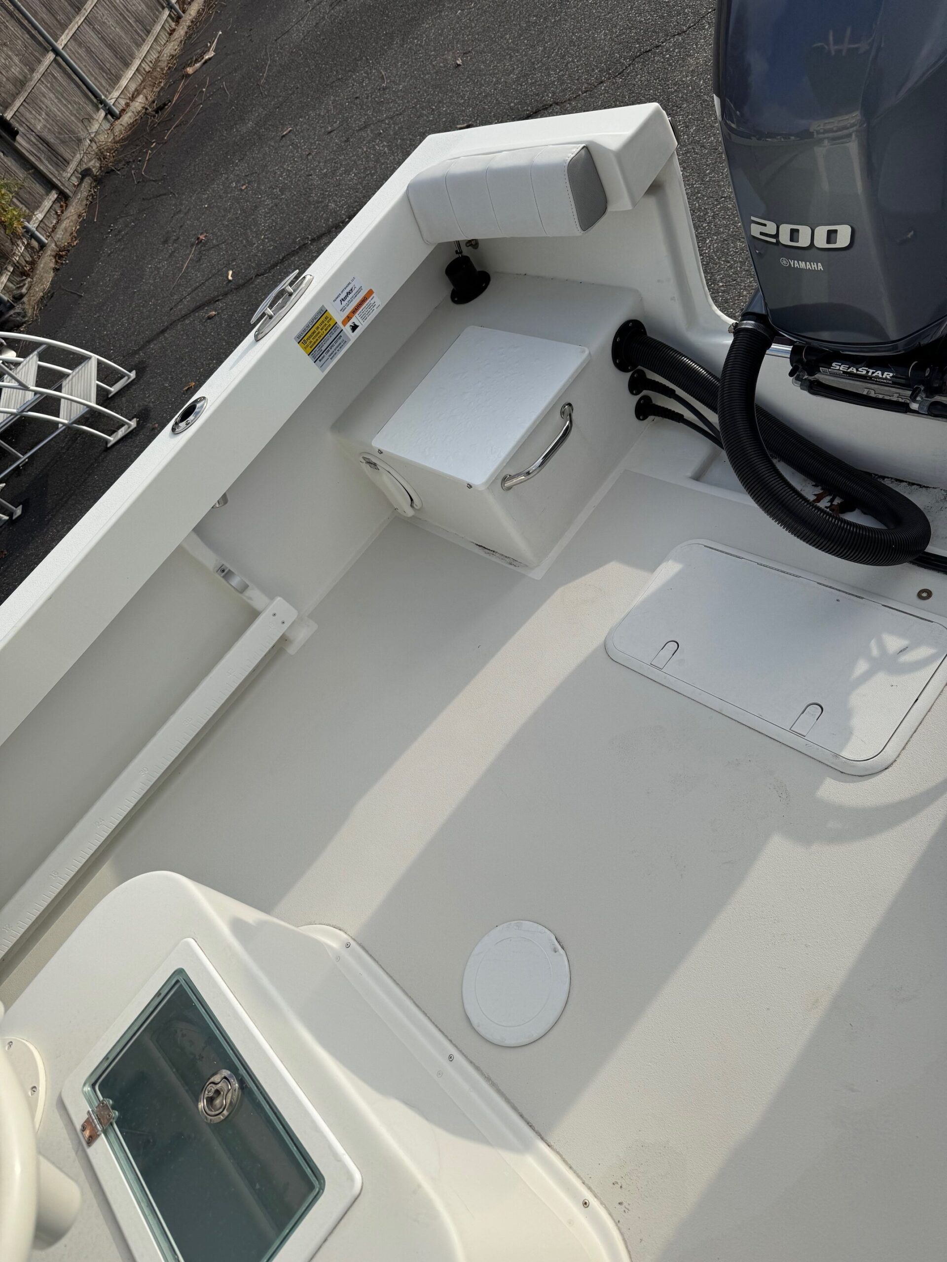 Sportsman Open 232 Center Console 2023: Spacious deck with motor and storage compartments.